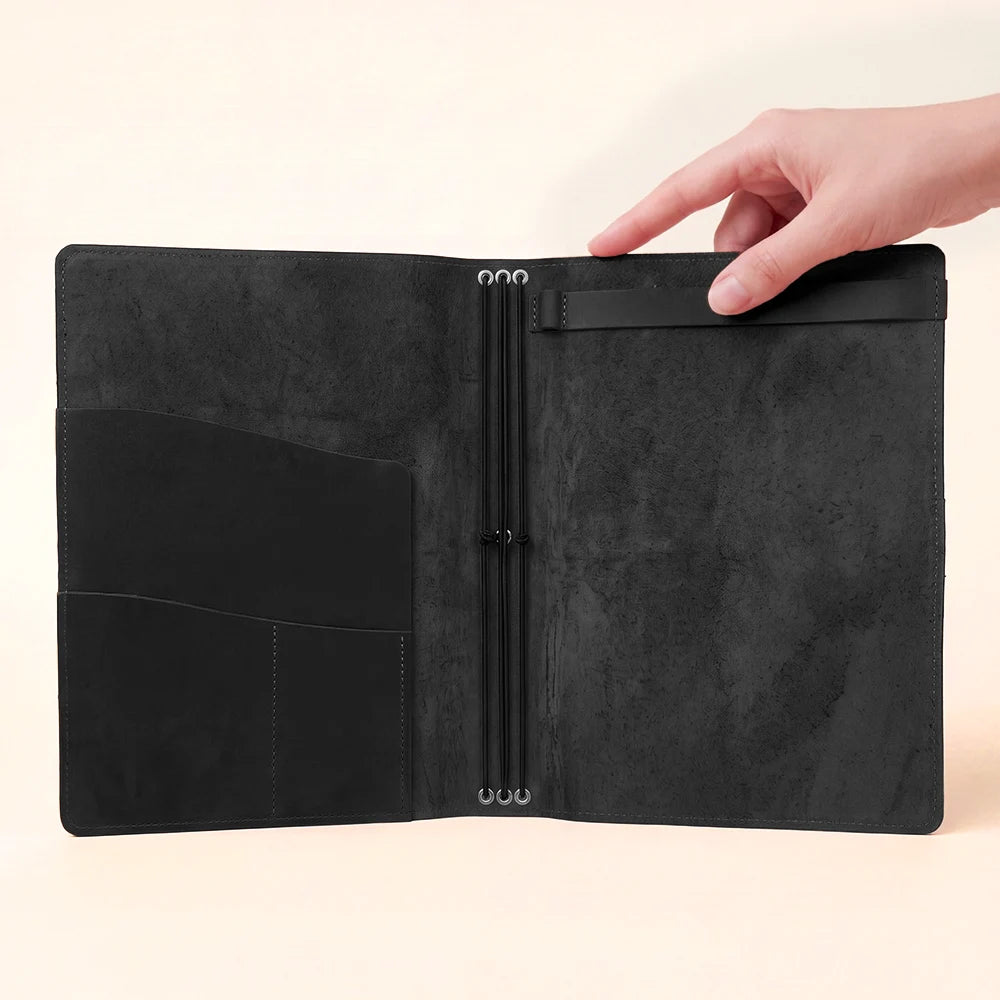 Open leather cover showcasing elastic notebook holders and carefully arranged storage pockets.
