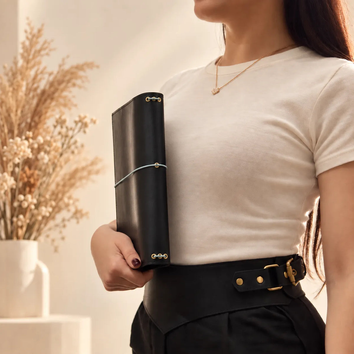 Woman presenting a leather journal cover with natural grain and carefully crafted edges.