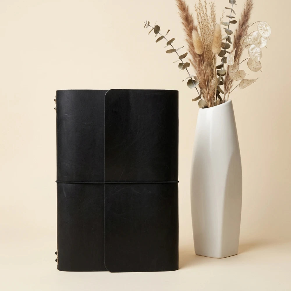 Handmade leather journal organizer with six interior bands and convenient pen storage.