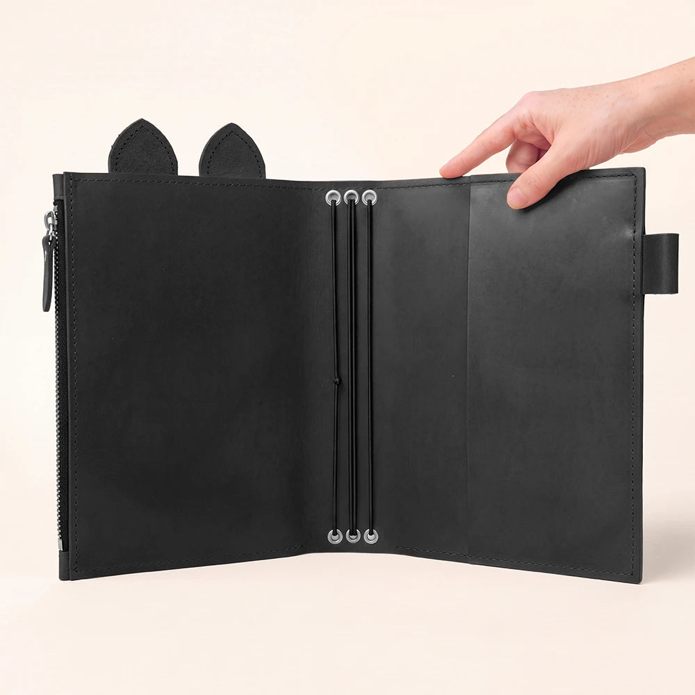 Open journal organizer crafted from natural leather with secure elastic insert holders.