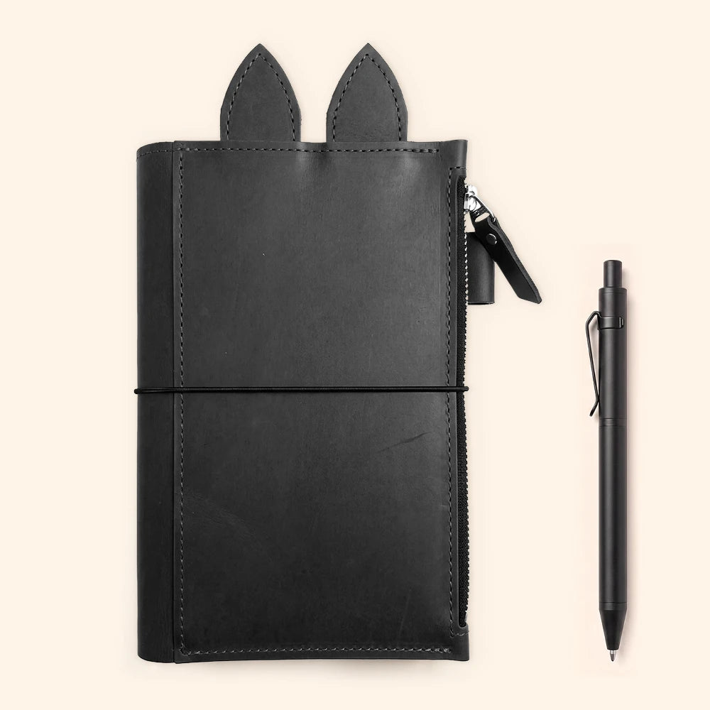 Handmade journal case displaying decorative leather ears above the stitched interior pocket.
