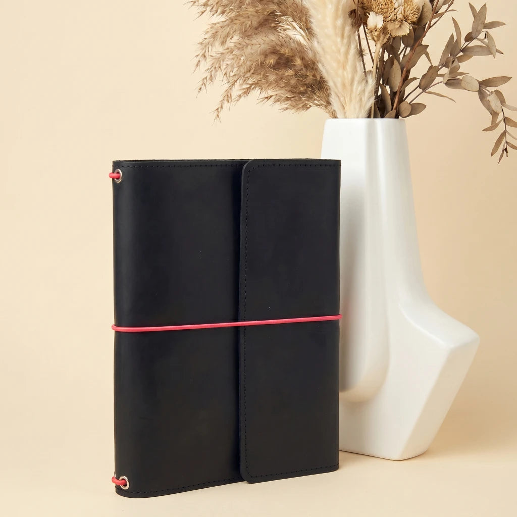 Durable leather journal organizer with elastic fastening and interior storage details