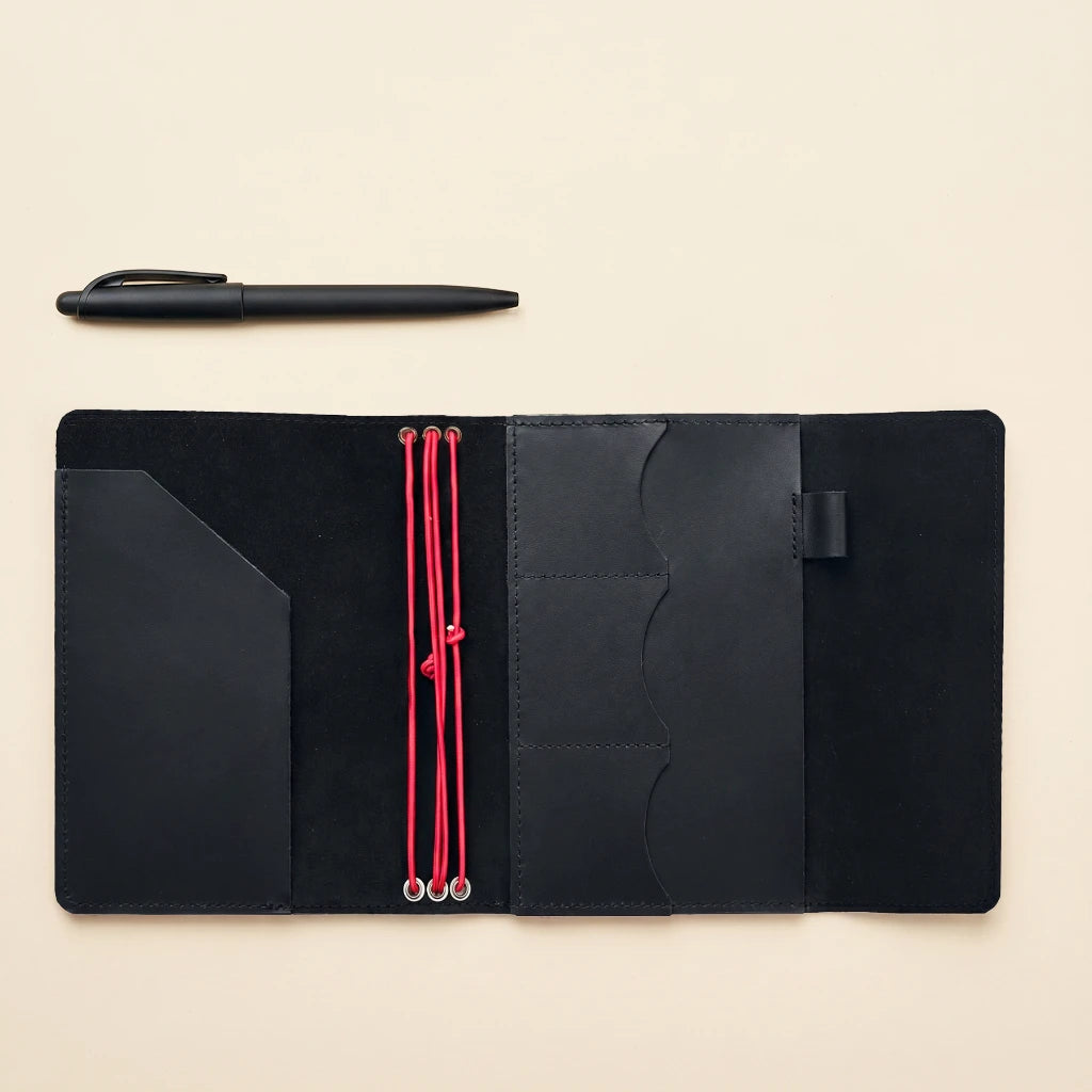 Handcrafted leather notebook holder with elastic bands, storage pockets, and pen loop