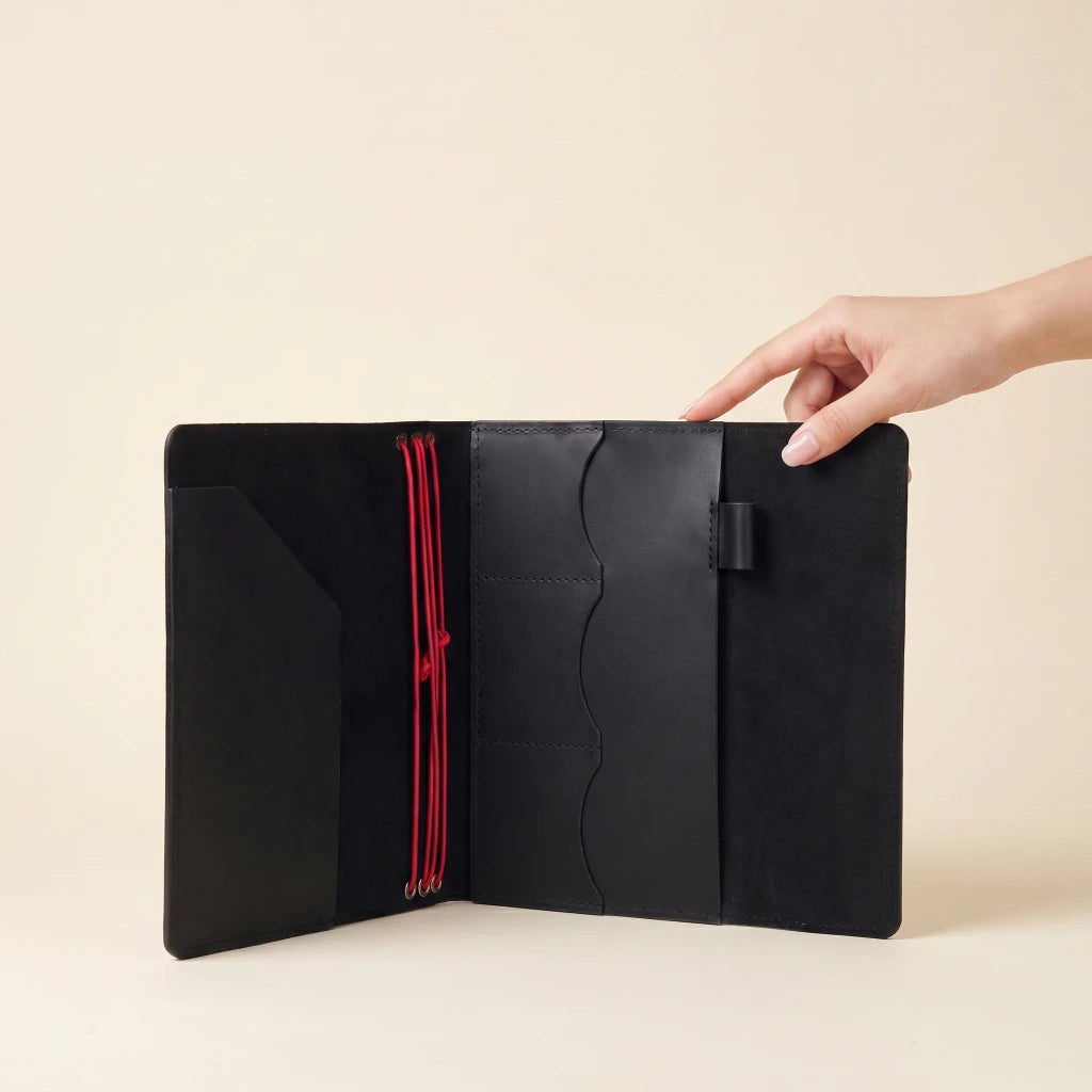 Leather notebook wrap featuring elastic closure, storage pockets, and pen carrying loop