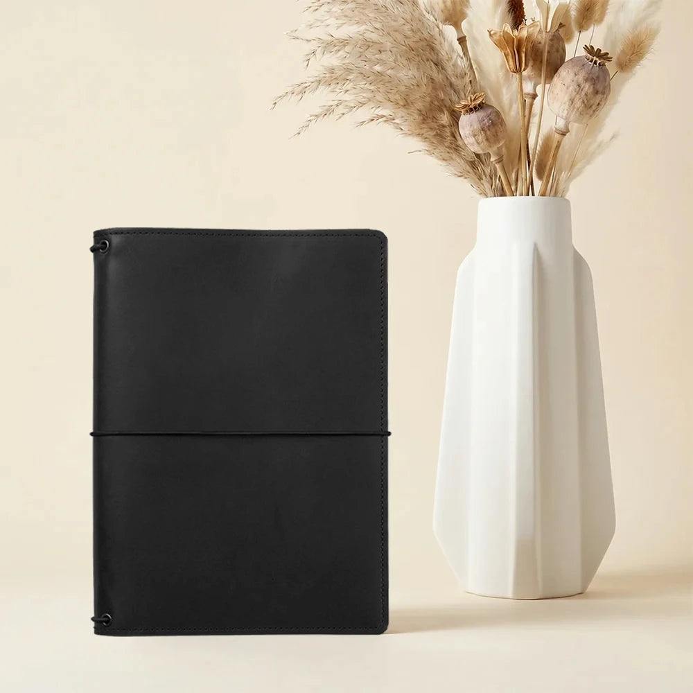 Leather notebook organizer crafted for refillable journals with practical storage pockets.