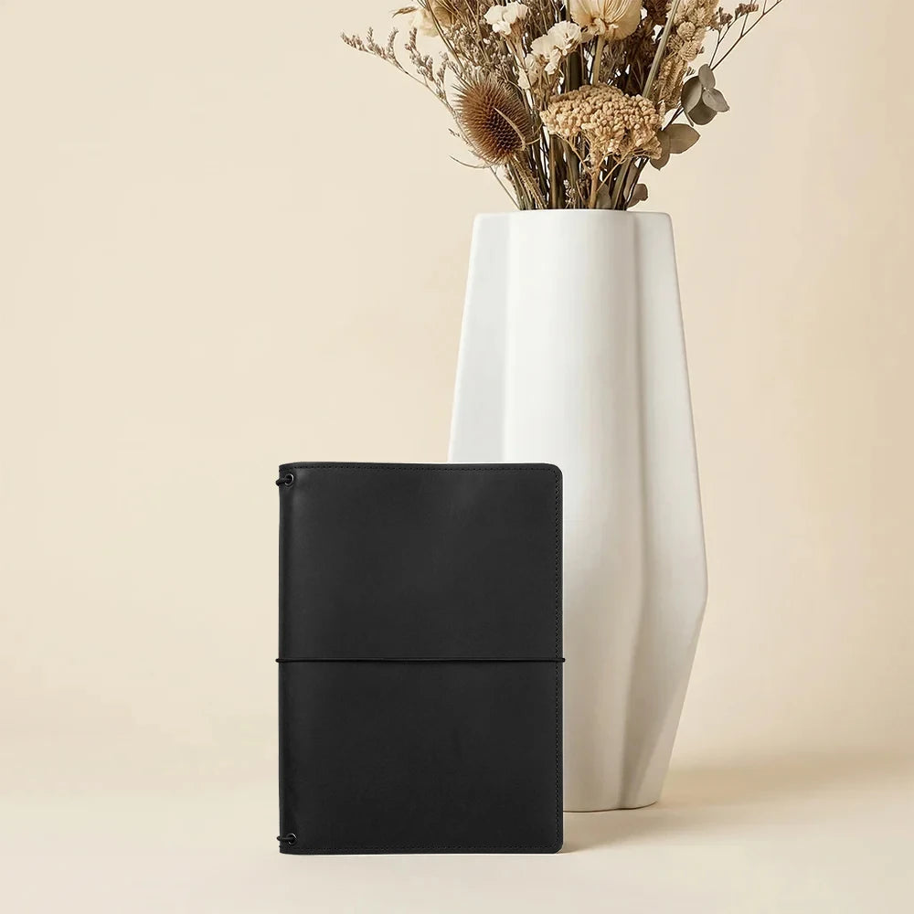 Rustic leather notebook cover with practical storage pockets and three secure elastic bands.
