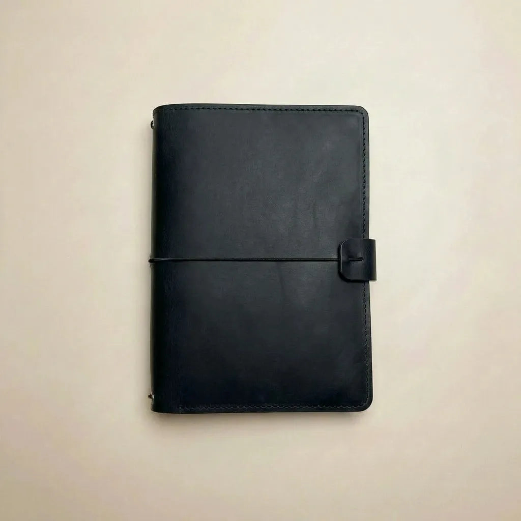 Refillable leather cover with three elastics and document pockets.