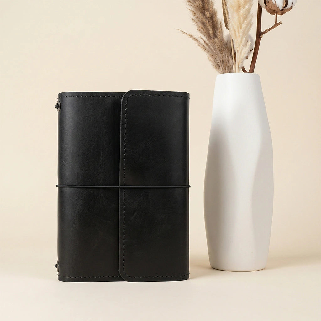 Leather refillable notebook cover with handcrafted details and secure pen storage loop.