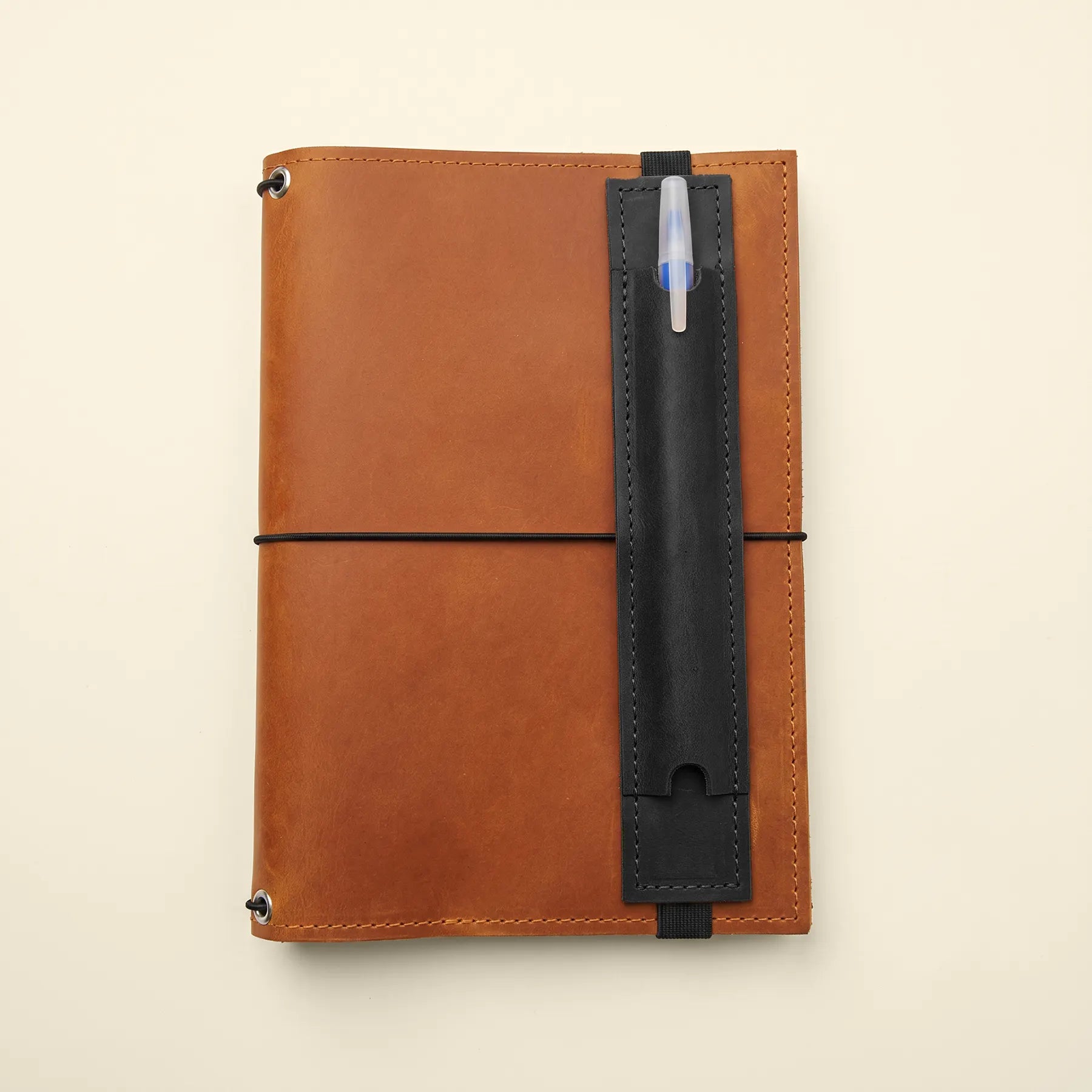 Elegant handcrafted leather pen loop accessory for notebooks with durable elastic backing.