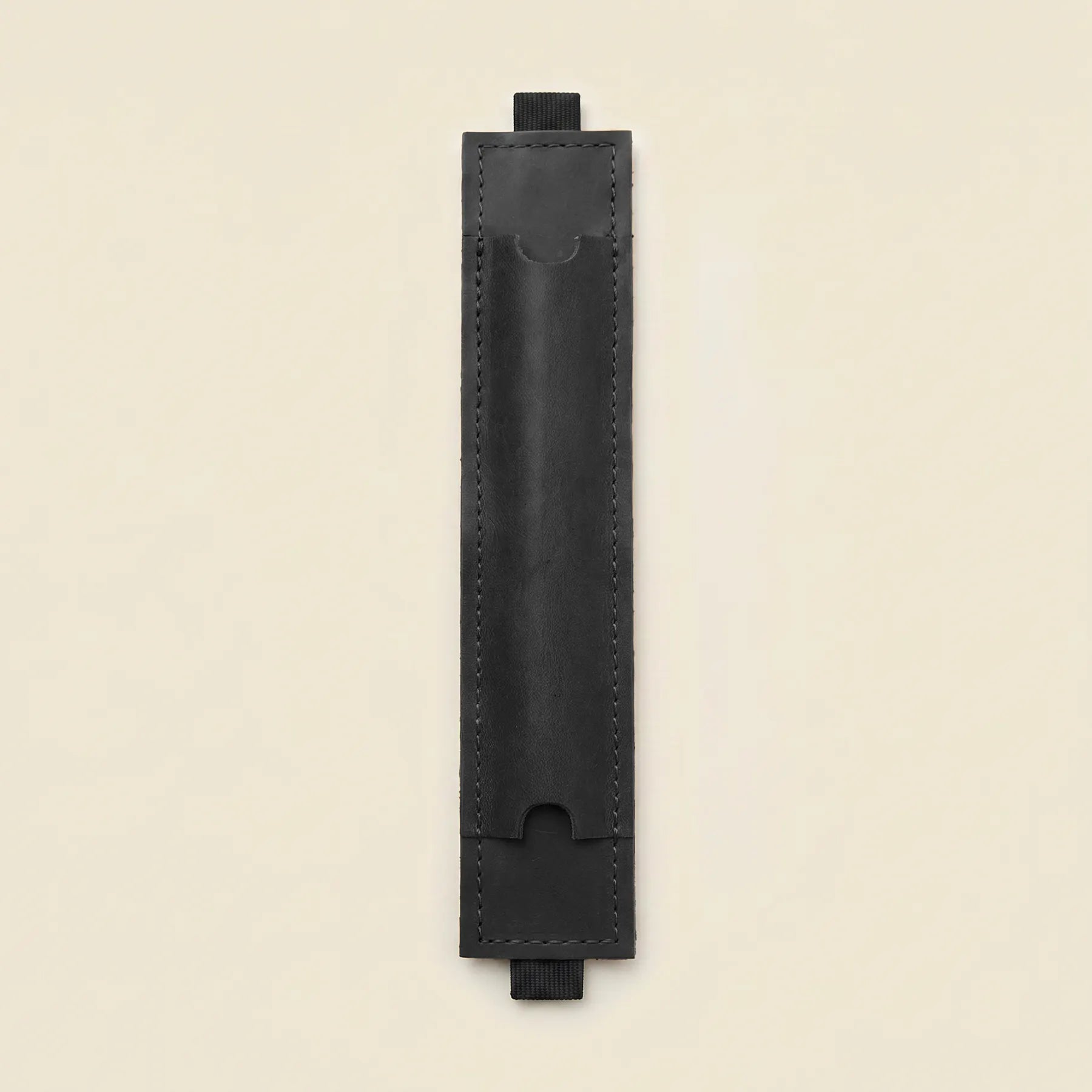 Leather pen holder with wide elastic strap providing secure notebook attachment and convenience.