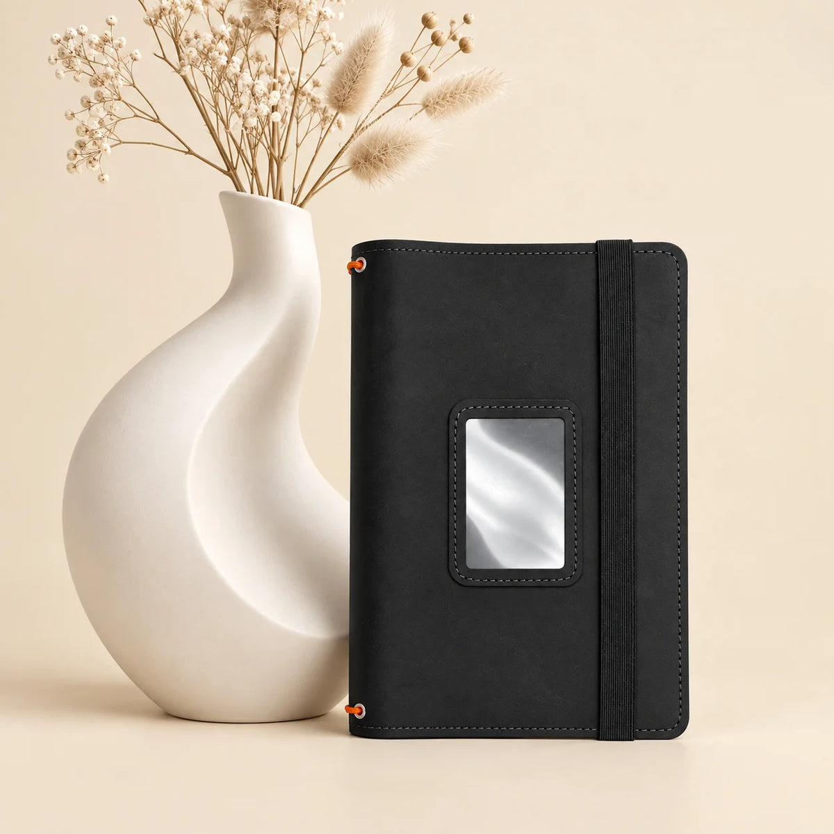 Natural leather journal cover displaying three notebook holders and spacious internal storage pockets.