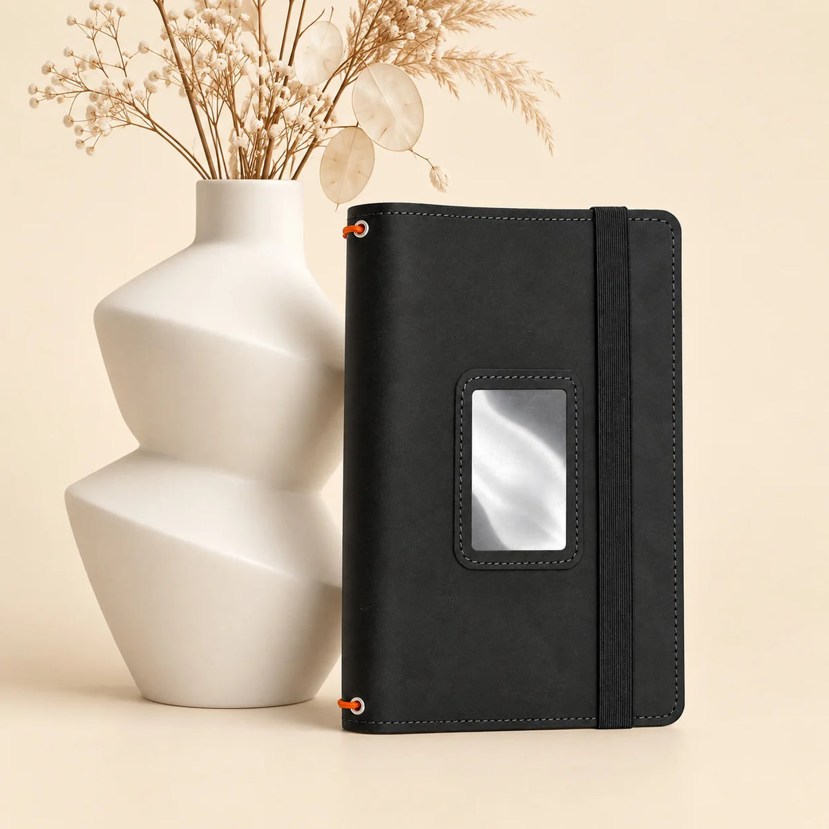 Leather notebook cover with three elastic bands and multiple interior pockets for organization.