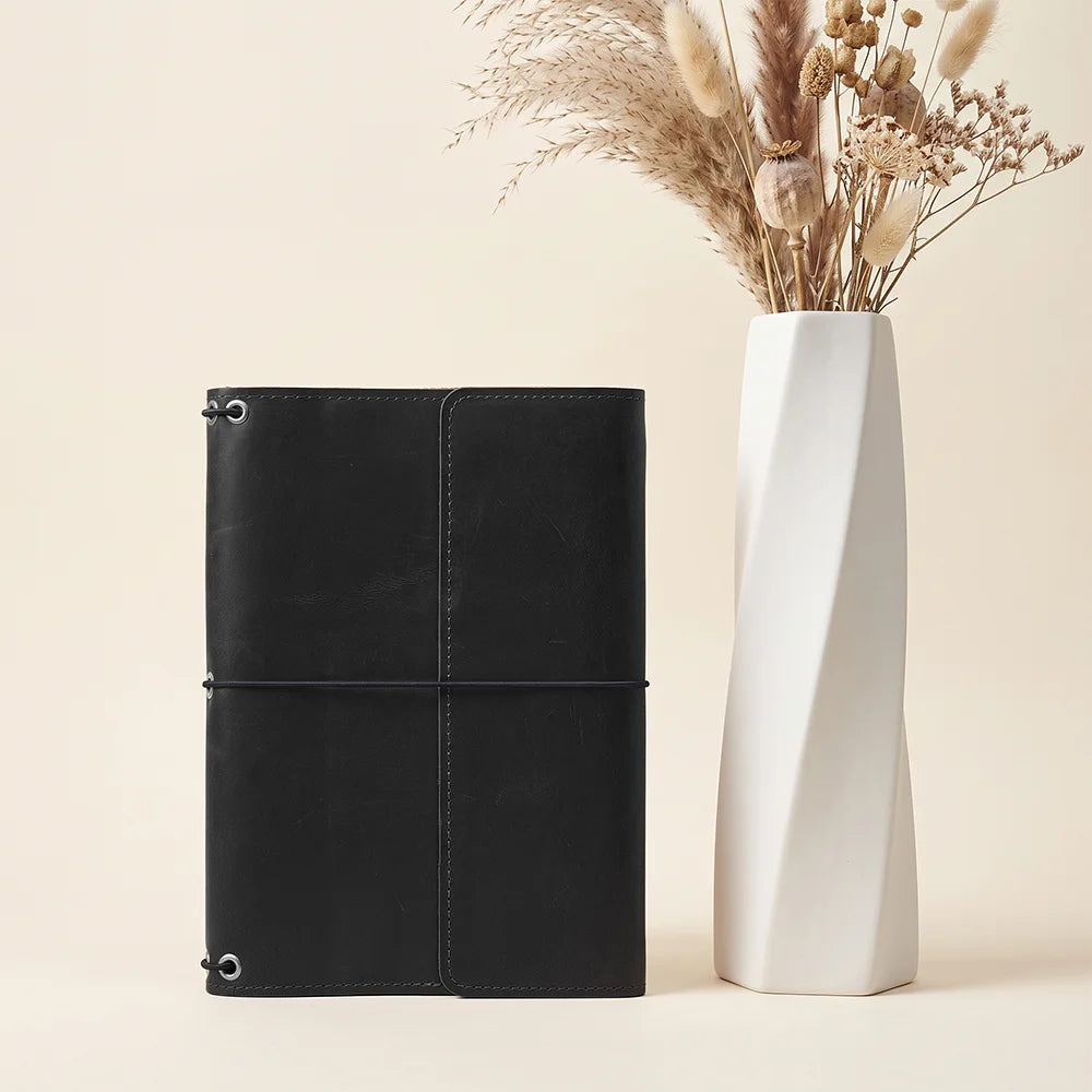 Leather notebook sleeve with refillable insert system and organized pockets for everyday carry.