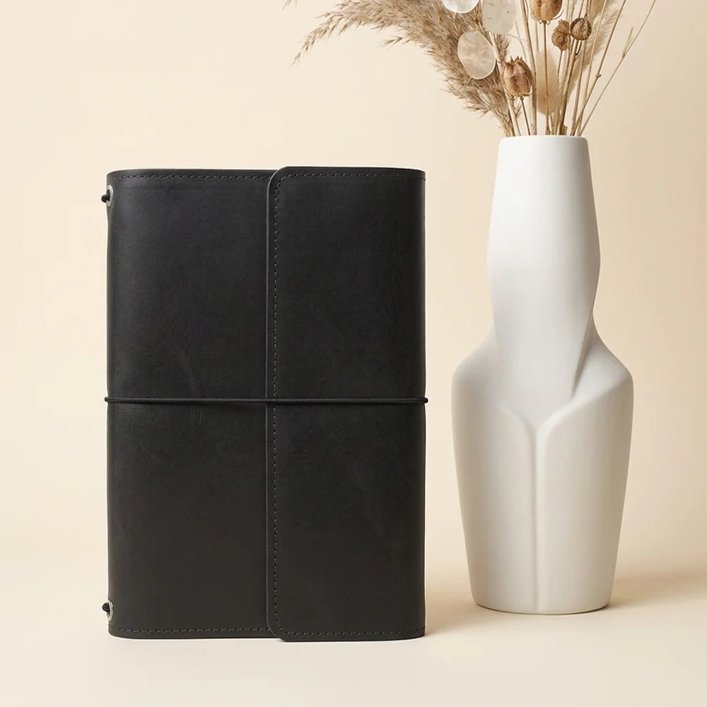 Artisan leather notebook cover featuring neat interior pockets and a convenient elastic writing tool strap.