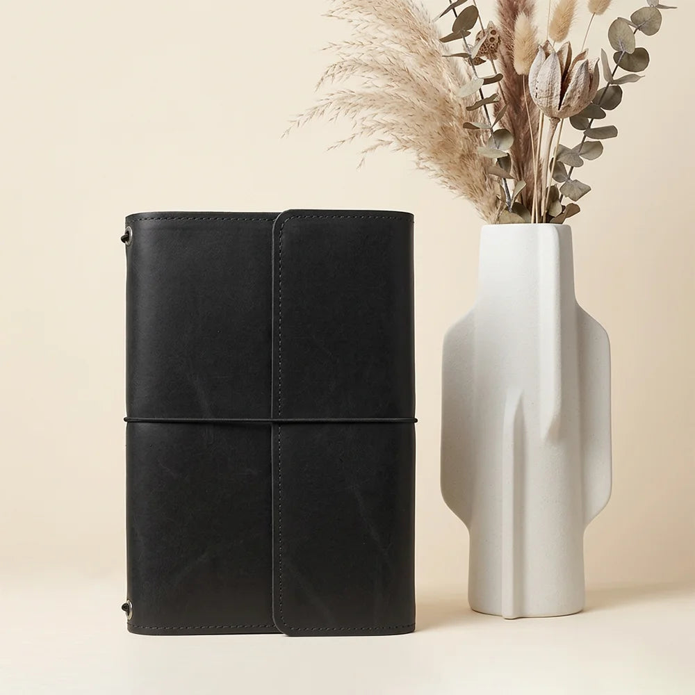 Leather journal cover with carefully stitched pockets and an integrated elastic pen keeper.