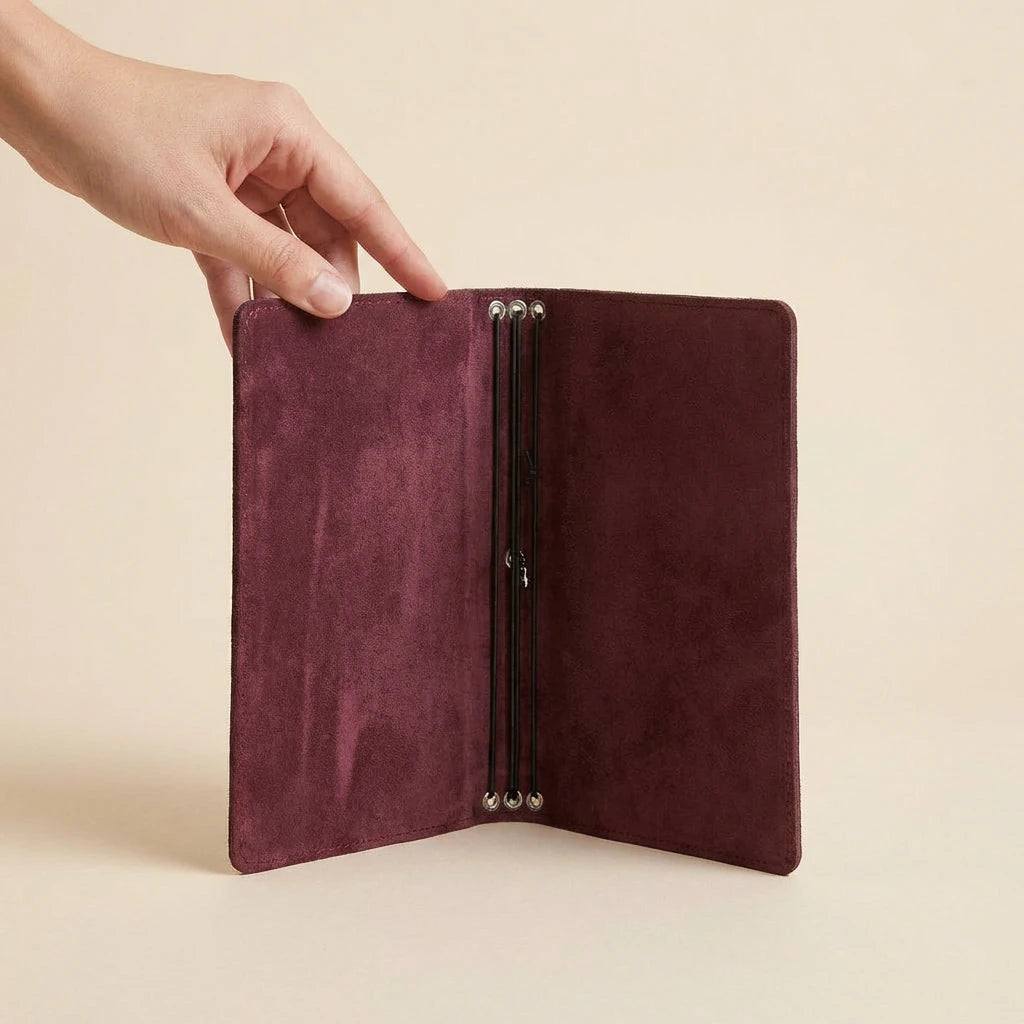 Mauve leather journal with metal clasps on a beige background