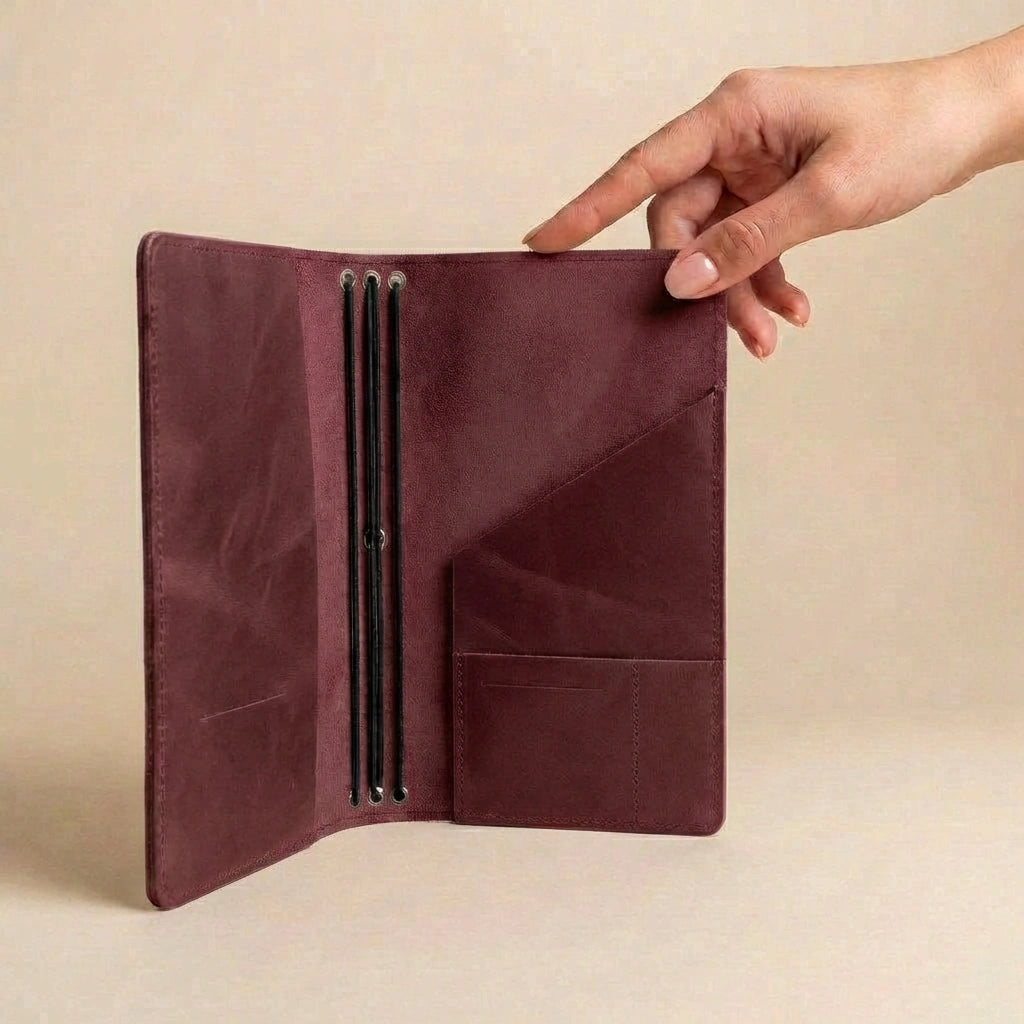 Brown leather wallet held open by a hand on a beige background