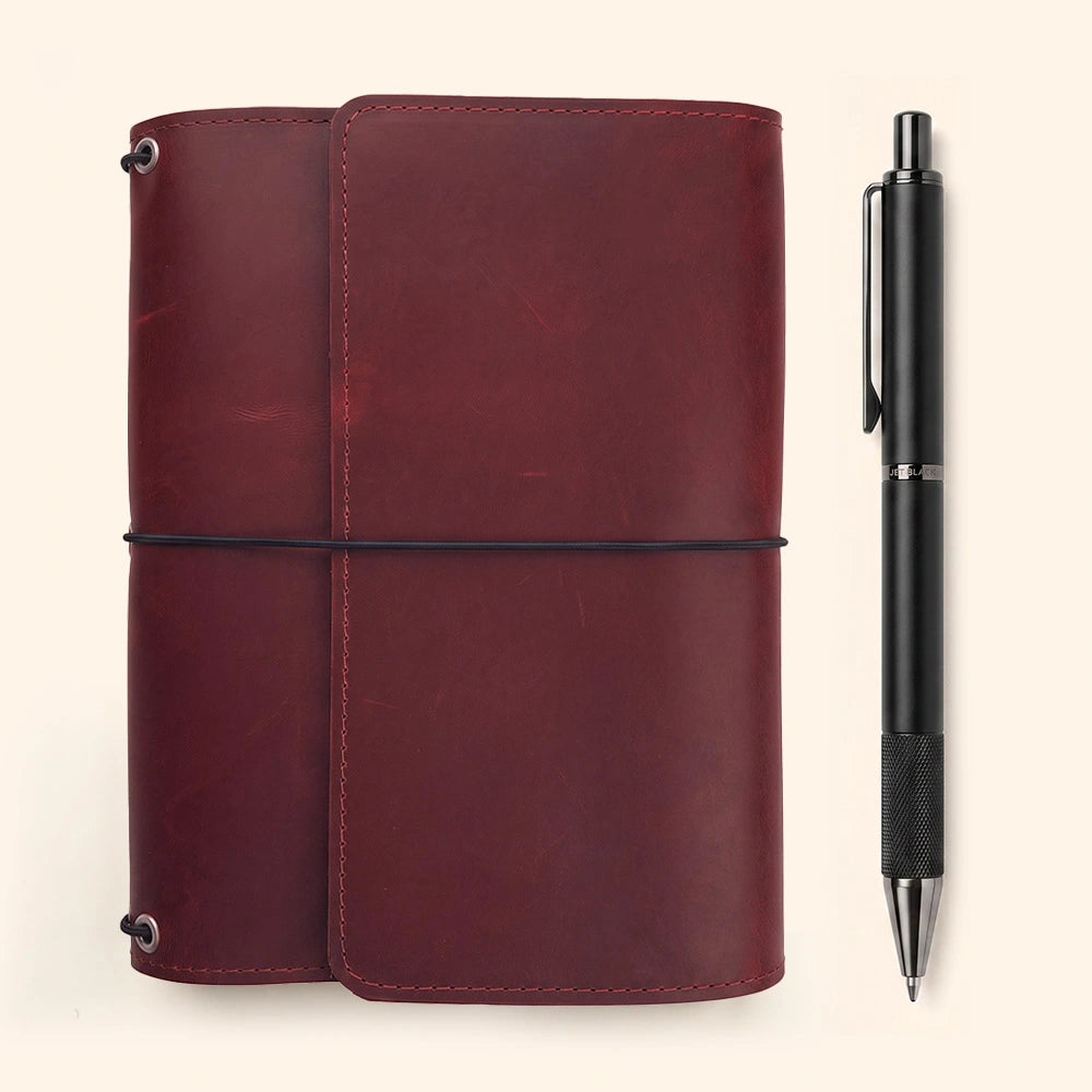 Handmade leather refillable notebook cover with organized storage pockets and pen loop.