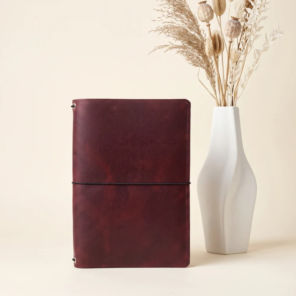 Stylish leather journal cover designed to hold three refillable notebook inserts securely.