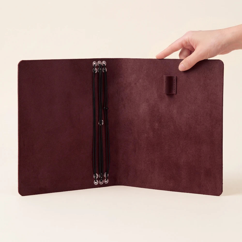 Handcrafted writing cover in genuine leather with six elastic insert attachments.