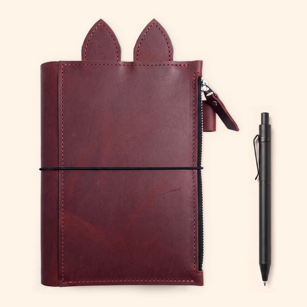 Leather journal cover displaying three elastics arranged neatly across the center.