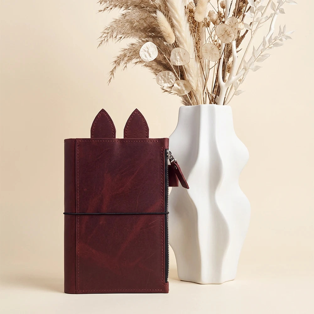 Handcrafted leather organizer with playful ear accents rising above the main compartment.