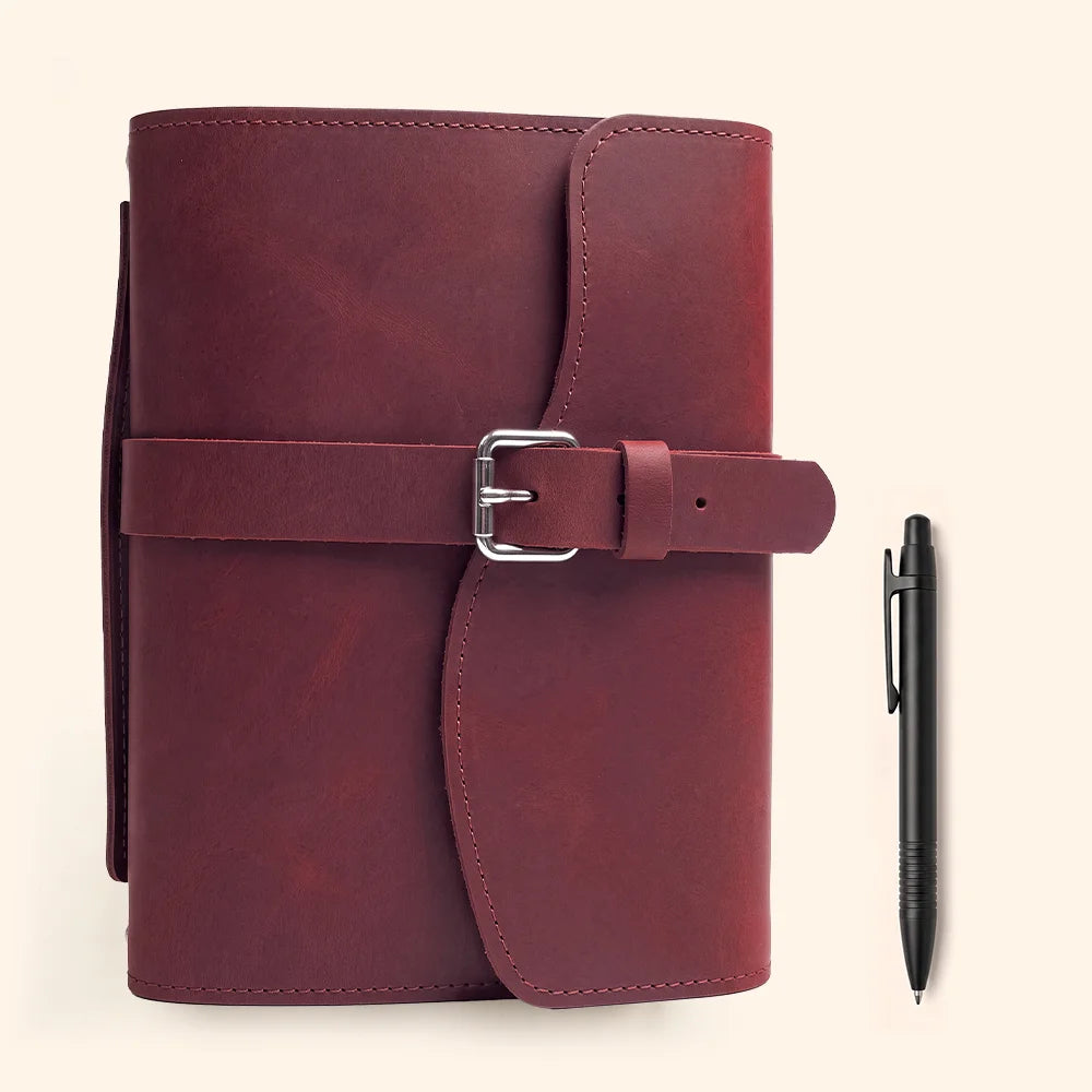 Leather journal cover with inner pockets, secure pen loop, attached marker, and sturdy external handle.
