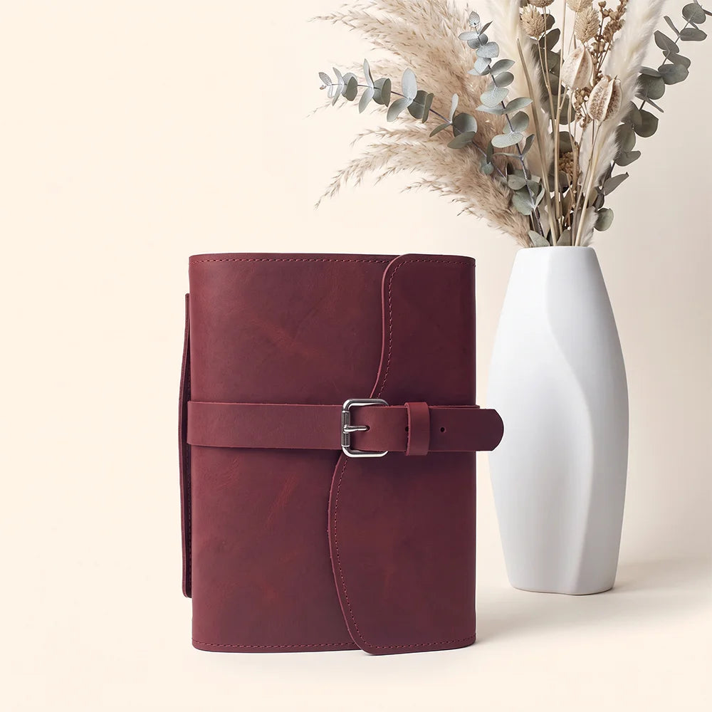 Leather notebook organizer featuring useful interior pockets, secure pen loop, integrated bookmark, and external handle.
