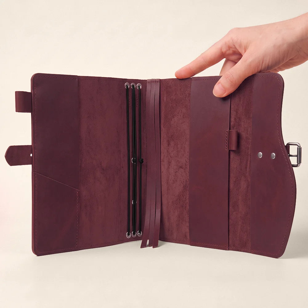 Handmade natural leather notebook cover with pockets, pen holder, bookmark, and practical carrying handle.