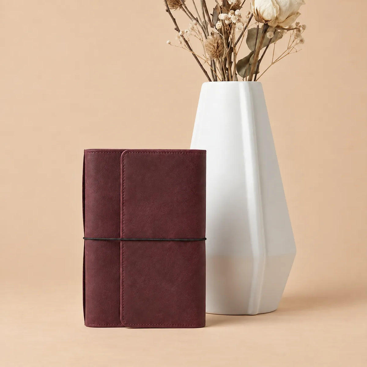 Handmade burgundy leather journal cover featuring six elastic bands, multiple pockets, and pen holder.