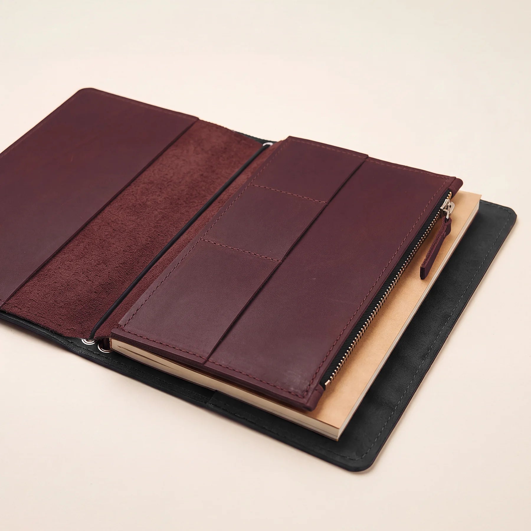 Refillable leather journal insert with secure elastic attachment and storage compartments.