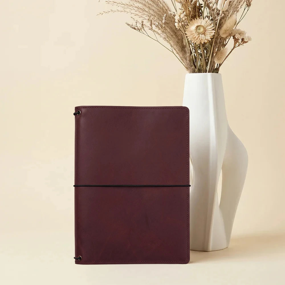 Leather notebook holder crafted with interior storage and secure elastic notebook retention.