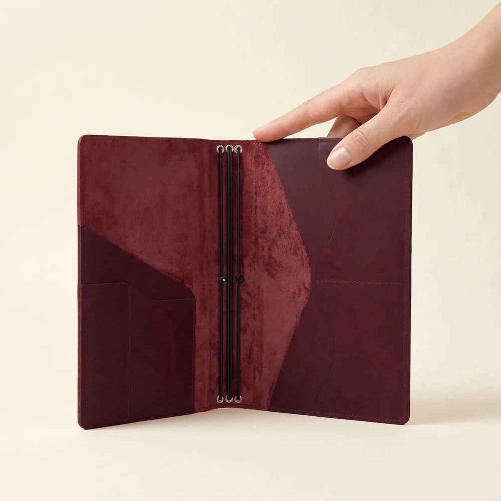 Handmade leather planner cover with three elastic notebook holders and practical storage pockets.