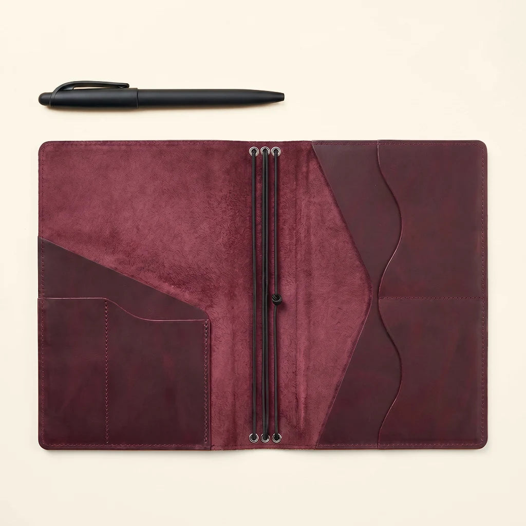 Durable leather journal cover with multiple pockets and elastic inserts.