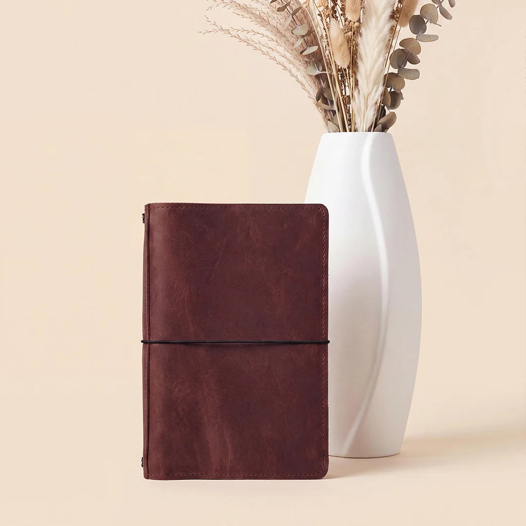 Handmade notebook cover with interior organizer sleeves and durable refillable elastic bands.