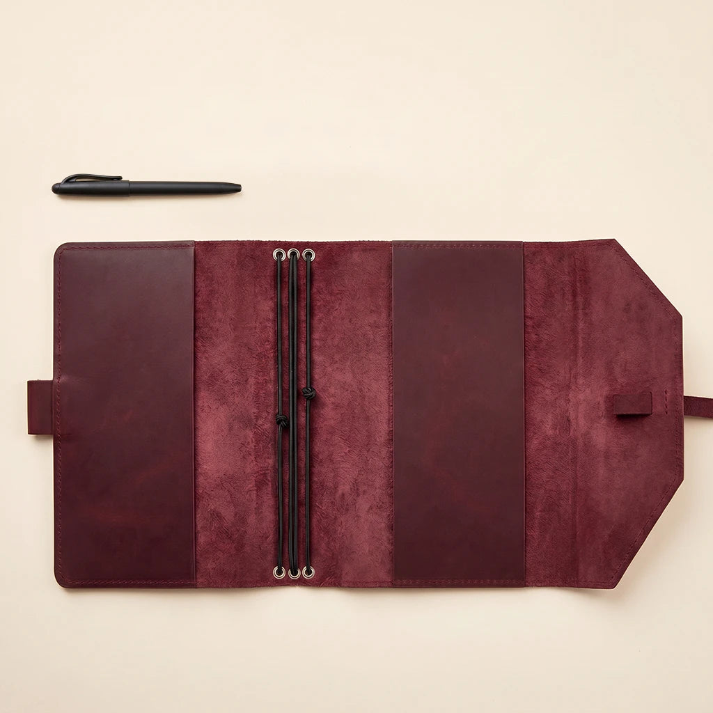 Compact leather notebook accessory with reliable elastic retention system.