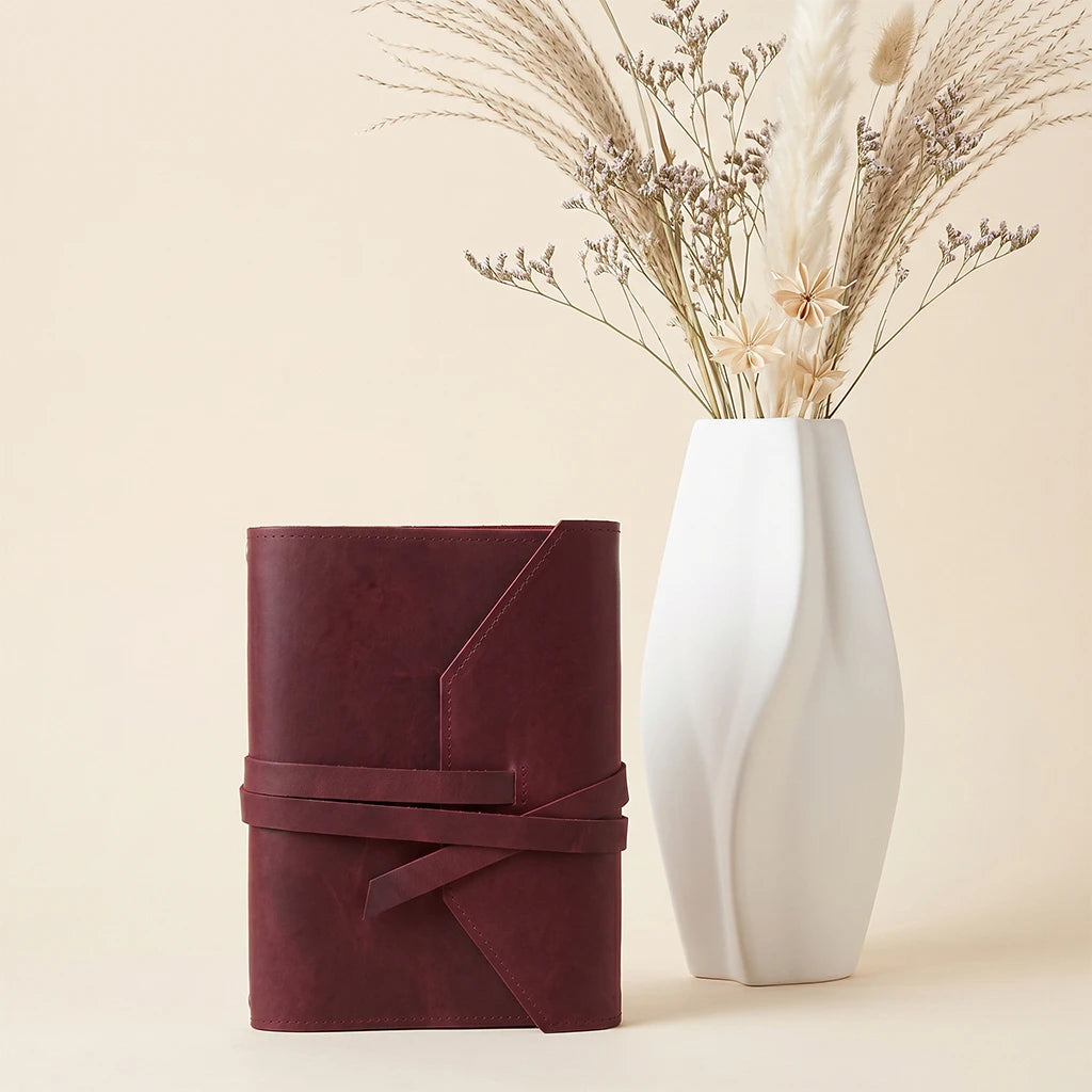 Leather journal cover designed with elastic bands and integrated pen holder.
