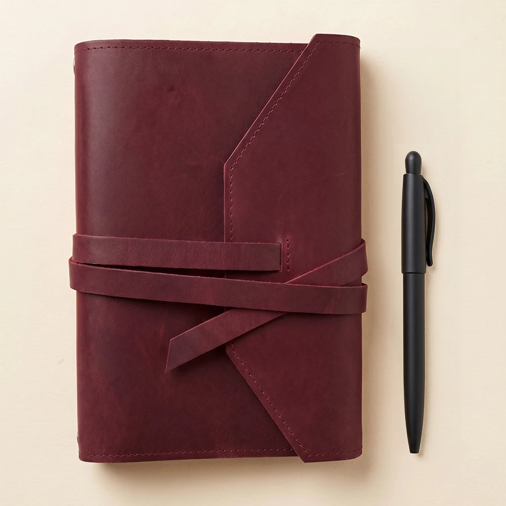 Refillable leather notebook cover made for daily use with elastics and pen holder.