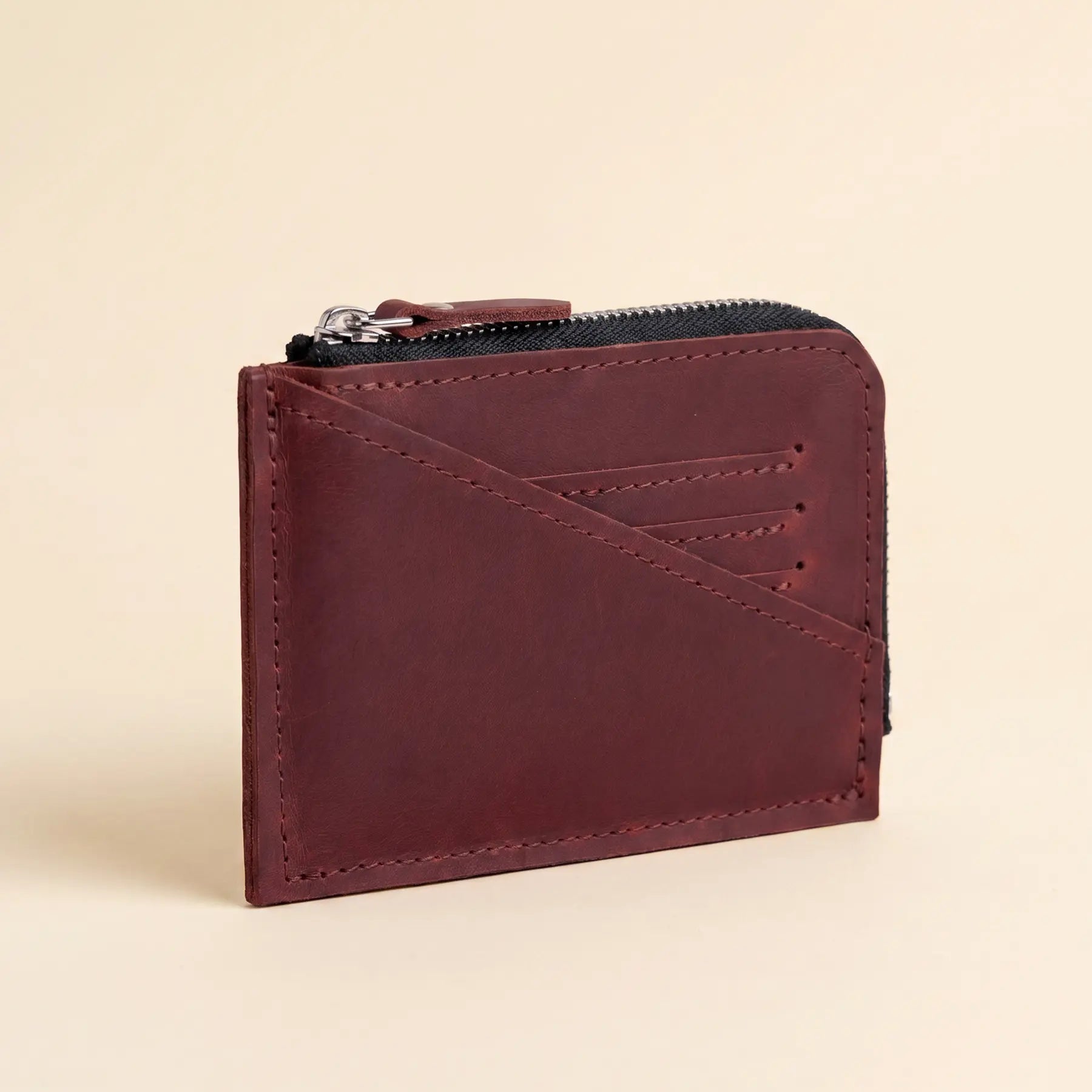 Small handcrafted leather wallet with smooth zipper closure for organized everyday essentials and cards.