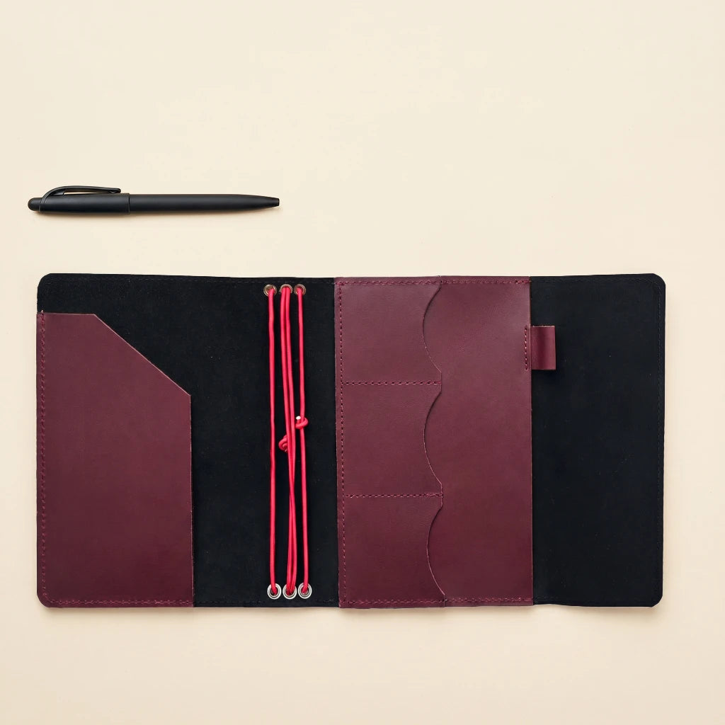 Leather notebook cover designed with elastic bands, accessory pockets, and pen loop