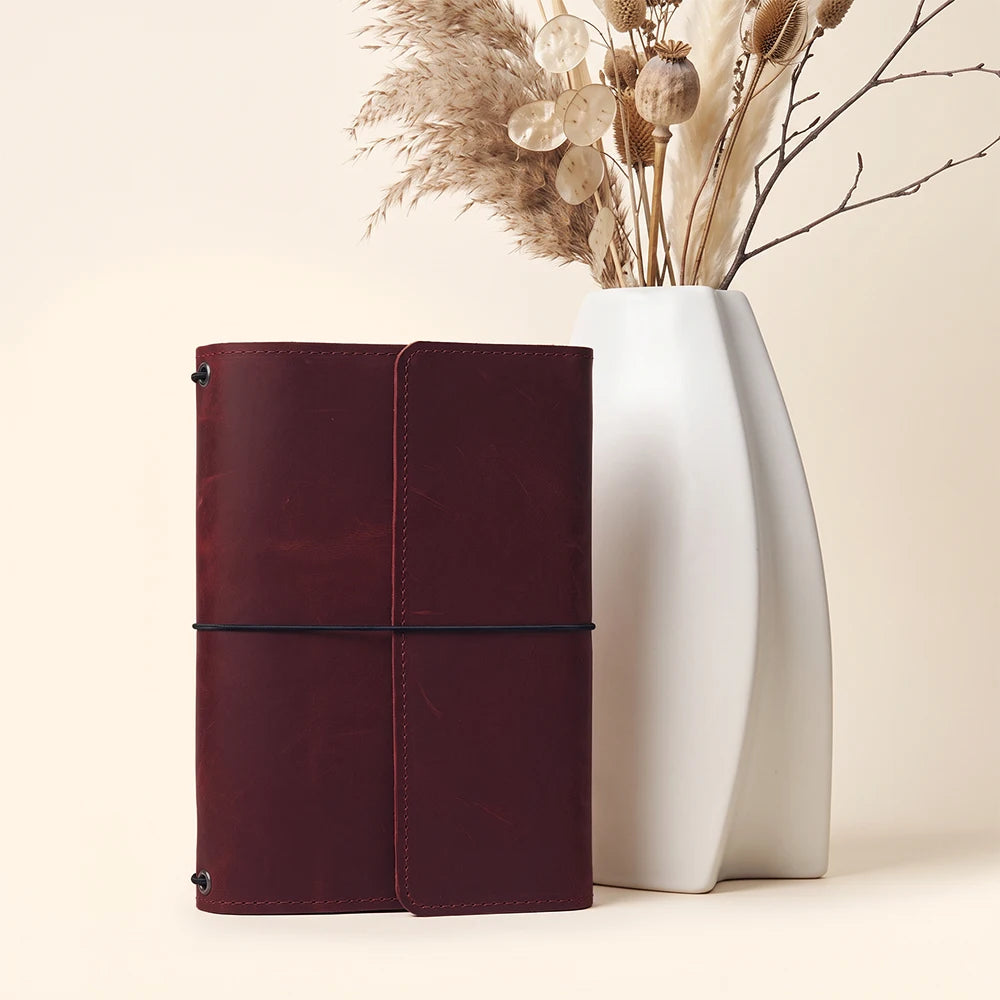 Leather notebook cover with structured interior layout and secure journal insert elastics.