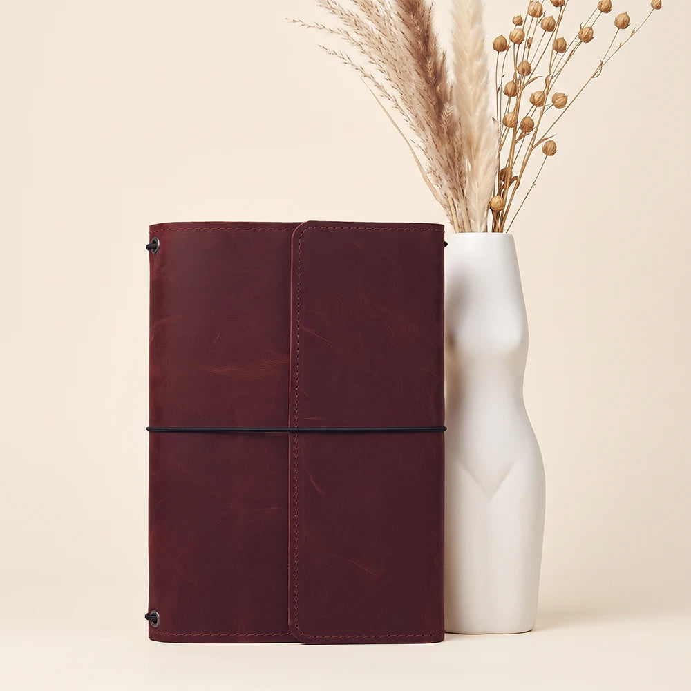 Elegant leather journal case with refillable insert system and multiple interior utility pockets.