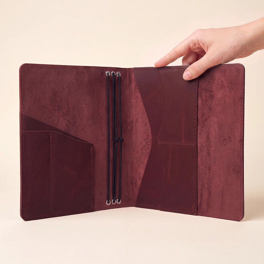 Leather planner organizer featuring handcrafted construction, pen loop, and three elastic notebook bands.
