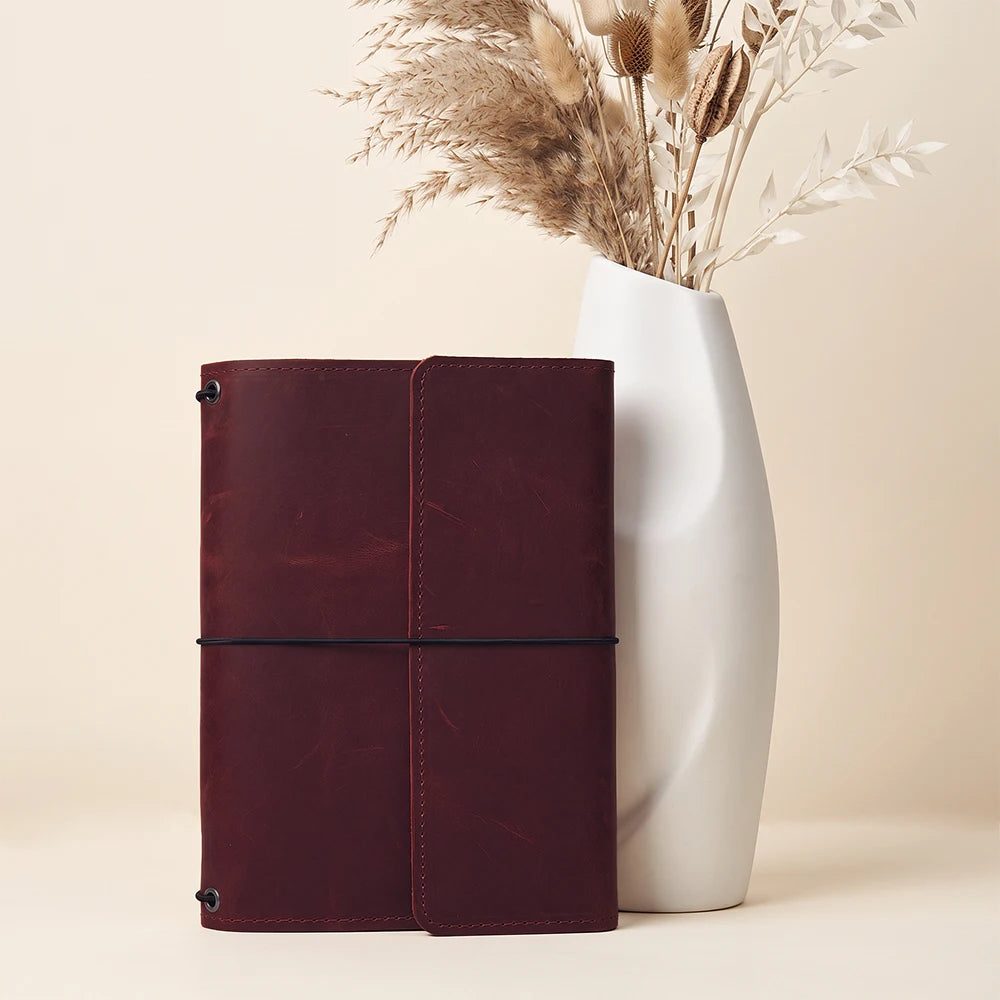 Refillable genuine leather notebook cover with organized interior pockets and pen holder included.