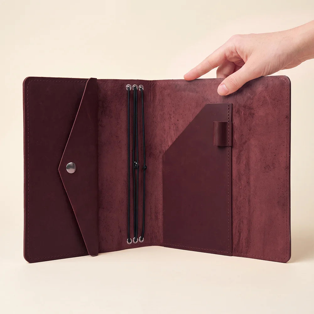 Handmade leather notebook case keeping journal inserts neatly organized and easily replaceable every day.