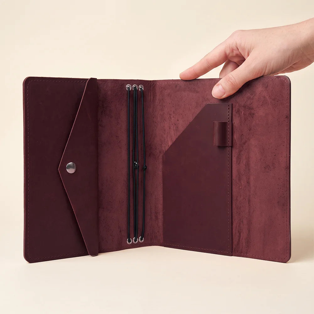 Compact leather journal holder with elastic notebook system and spacious internal storage pockets.