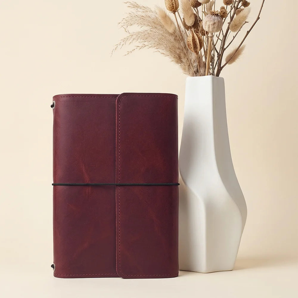 Handmade leather journal cover with multiple interior compartments and a convenient pen loop