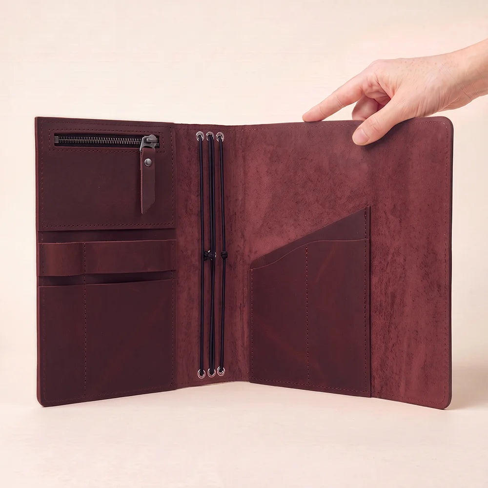 Premium leather notebook cover featuring useful interior sections and dedicated writing instrument storage.
