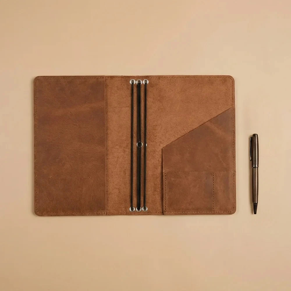 Refillable leather notebook wallet with organizer compartments and flexible elastic holding system.