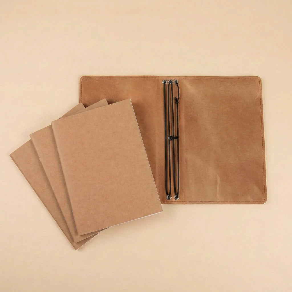 Brown leather-bound notebook with pen holder on a beige background